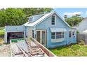 Quaint blue bungalow featuring a bright exterior with a dumpster in the driveway at 104 N Park Pl, Edgewater, FL 32132