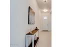 Bright hallway with a console table and artwork on the wall leading to the front door at 112 Chelsea Place Ave, Ormond Beach, FL 32174