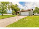 Beautiful home featuring well-manicured lawn, long driveway, and two car garage at 1166 Tracy Dr, Port Orange, FL 32129