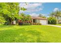 Inviting curb appeal with lush green lawn, mature landscaping, and a charming single story home at 1166 Tracy Dr, Port Orange, FL 32129