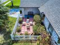 Aerial view of a landscaped brick patio with white picket fence, seating, and mature plants at 1229 Jeffery Dr, Port Orange, FL 32129
