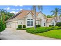 Well-maintained house with a side-entry garage, tile roof, lush landscaping, and a paved driveway with ample parking at 1324 Dovercourt Ln, Ormond Beach, FL 32174