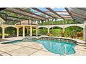 Resort-style screened pool and spa with cabana, waterfall feature, and serene golf course views at 1324 Dovercourt Ln, Ormond Beach, FL 32174