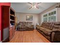 Cozy living room with brown leather furniture, wood floors, and natural light from the window at 137 Fort Smith Blvd, Deltona, FL 32738