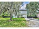 View of the charming two story home surrounded by lush landscaping and an open front lawn at 1398 5Th Ave, Deland, FL 32724