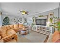 Spacious living room with a large tan leather couch, ceiling fan, and wood flooring at 1398 5Th Ave, Deland, FL 32724
