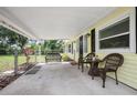 Inviting covered front porch with seating and a view of the front yard at 1402 E Voorhis Ave, Deland, FL 32724