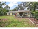 Lovely single-story home with a fenced yard and cozy front porch at 1402 E Voorhis Ave, Deland, FL 32724