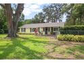 Beautiful home with lush green lawn and a charming front porch area at 1402 E Voorhis Ave, Deland, FL 32724