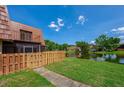 Beautiful backyard view of a home with a pond view and a wooden fence at 152 Sweetgum Ln, Port Orange, FL 32129