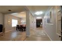 Light-filled hallway with decorative lighting leads to dining area with wood table, kitchen and living spaces at 1632 Blue Grass Blvd, Deland, FL 32724