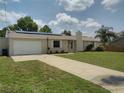 Charming single-story home featuring an attached garage, solar panels, and a well-maintained lawn at 1821 Talmadge St, Deland, FL 32724