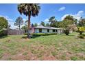 Attractive single-story home with mature trees and an American flag waving in the yard at 1828 West Pkwy, Deland, FL 32724