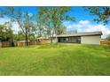 Large, grassy backyard with a wooden fence, providing a private and spacious area for outdoor activities at 1917 Alameda Dr, Deltona, FL 32738