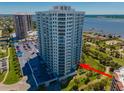 High-rise condo building with a parking area, golf course, and scenic water views at 2 Oceans West Blvd # 305, Daytona Beach, FL 32118
