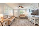 Light-filled living room with wood-look flooring, plantation shutters and comfortable tan sofas at 203 Fox Pl, Port Orange, FL 32127