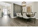 Stylish dining room with gray accent wall, pendant lighting, hardwood floors and seating for six at 241 Old Moss Cir, Deland, FL 32724