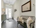 Bright foyer showcasing a tray ceiling, dark floors, bench with pillows, and attractive decor at 241 Old Moss Cir, Deland, FL 32724