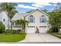Charming two-story home featuring a two-car garage and lush landscaping with palm trees at 275 Bayou Cir, Debary, FL 32713