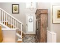 Light-filled foyer with wooden staircase, beautiful cabinet and decorative accents at 275 Bayou Cir, Debary, FL 32713