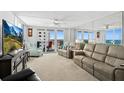 Open living room with couches, TV, ceiling fan, and balcony access with water views at 2987 S Atlantic Ave # 901, Daytona Beach, FL 32118