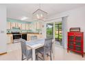 Eat-in kitchen with tiled floor, modern light fixture and stainless appliances. Sliding doors to patio at 3035 Victory Palms Dr, Edgewater, FL 32141