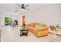 Bright living room featuring a ceiling fan, tile floors, and sliding glass doors to the backyard at 3035 Victory Palms Dr, Edgewater, FL 32141