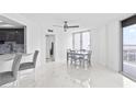 Dining area with modern table and ceiling fan, featuring large windows with ocean views at 3047 S Atlantic Ave # 1805, Daytona Beach, FL 32118