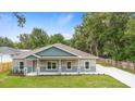Charming, newly built single-Gathering home featuring a covered front porch, green lawn, and modern two-tone exterior at 349 Baker Ave, Lake Helen, FL 32744
