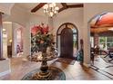Elegant foyer featuring a decorative table with floral arrangement, tile flooring, and a view of other rooms at 3592 Grande Tuscany Way, New Smyrna Beach, FL 32168