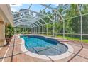 Screened-in pool with a brick surround, offering a private and relaxing outdoor space, surrounded by lush greenery at 3592 Grande Tuscany Way, New Smyrna Beach, FL 32168
