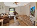 Inviting living room with vaulted ceiling, wood-look floors, comfortable seating, and large window at 414 Lancaster Ave, Orange City, FL 32763