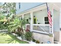 Inviting front porch with a lime green door, landscaping and an American flag at 417 S Palmetto Ave, Daytona Beach, FL 32114