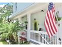 Inviting front porch with a lime green door and an American flag at 417 S Palmetto Ave, Daytona Beach, FL 32114