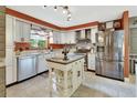 Bright kitchen featuring stainless steel appliances, white cabinets, an island, and stylish lighting at 535 Black Ironwood Dr, Deland, FL 32724