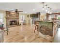 Open-concept living room with a stone fireplace and hardwood floors extending into the kitchen area at 535 Black Ironwood Dr, Deland, FL 32724