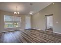 Bright living room featuring wood flooring, vaulted ceilings, chandelier, and a doorway to the bathroom at 6 Laurel Pass Ct, Ocala, FL 34480