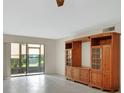 Bright living room featuring tile floors, built-in shelving, and sliding glass door to the porch at 600 N Boundary Ave # 110A, Deland, FL 32720