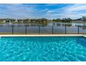 Backyard pool overlooking a tranquil lake, perfect for relaxation and outdoor entertaining at 6871 Forkmead Ln, Port Orange, FL 32128