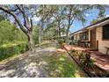 Spacious backyard with a wooden deck and red brick patio, leading to a serene waterfront view at 71 Crooked Pine Rd, Port Orange, FL 32128