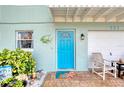 Inviting front entrance with a vibrant blue door, decorative fish accent, and cozy seating area at 721 Laurel Bay Cir, New Smyrna Beach, FL 32169