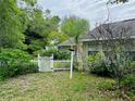 Enclosed backyard area with a white picket fence and a lush, green, landscaped garden at 733 E Ohio Ave, Deland, FL 32724