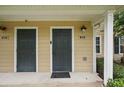 Up-close view of the doorways to units 102 and 202 with neutral siding and black doors at 944 Regatta Bay Dr # 12-102, Orange City, FL 32763