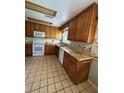 Functional kitchen equipped with wooden cabinets and tile flooring for easy maintenance at 96 Old Barn Trl, Ormond Beach, FL 32174