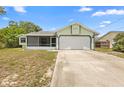 Charming single-story home featuring a two-car garage and a screened-in porch at 1018 E Gaucho Cir, Deltona, FL 32725