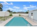 Inviting in-ground pool in a private backyard with white fence and storage shed, perfect for outdoor relaxation at 1027 Bel Aire Dr, Daytona Beach, FL 32118
