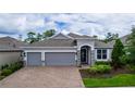 Charming single-story home with a brick driveway, three-car garage, and landscaped yard at 1227 Victoria Hills N Dr, Deland, FL 32724