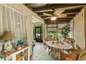 Cozy enclosed porch featuring wicker furniture, tiled flooring, and a stylish ceiling fan at 127 Cypress Pond Rd, Port Orange, FL 32128