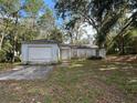 A single-Gathering home featuring an attached one-car garage and a front yard with mature trees at 1370 19Th St, Orange City, FL 32763