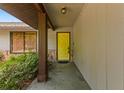 Welcoming entrance featuring a bright yellow front door, stone accents, and lush greenery at 1411 N Beach St, Ormond Beach, FL 32174